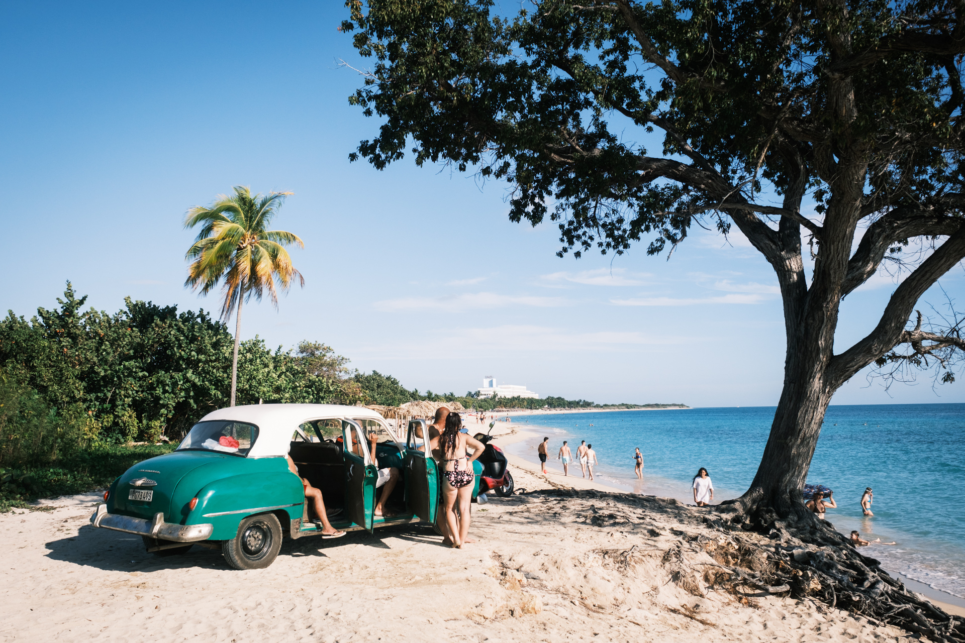 Kubaner mit Oldtimer am Playa Ancón.