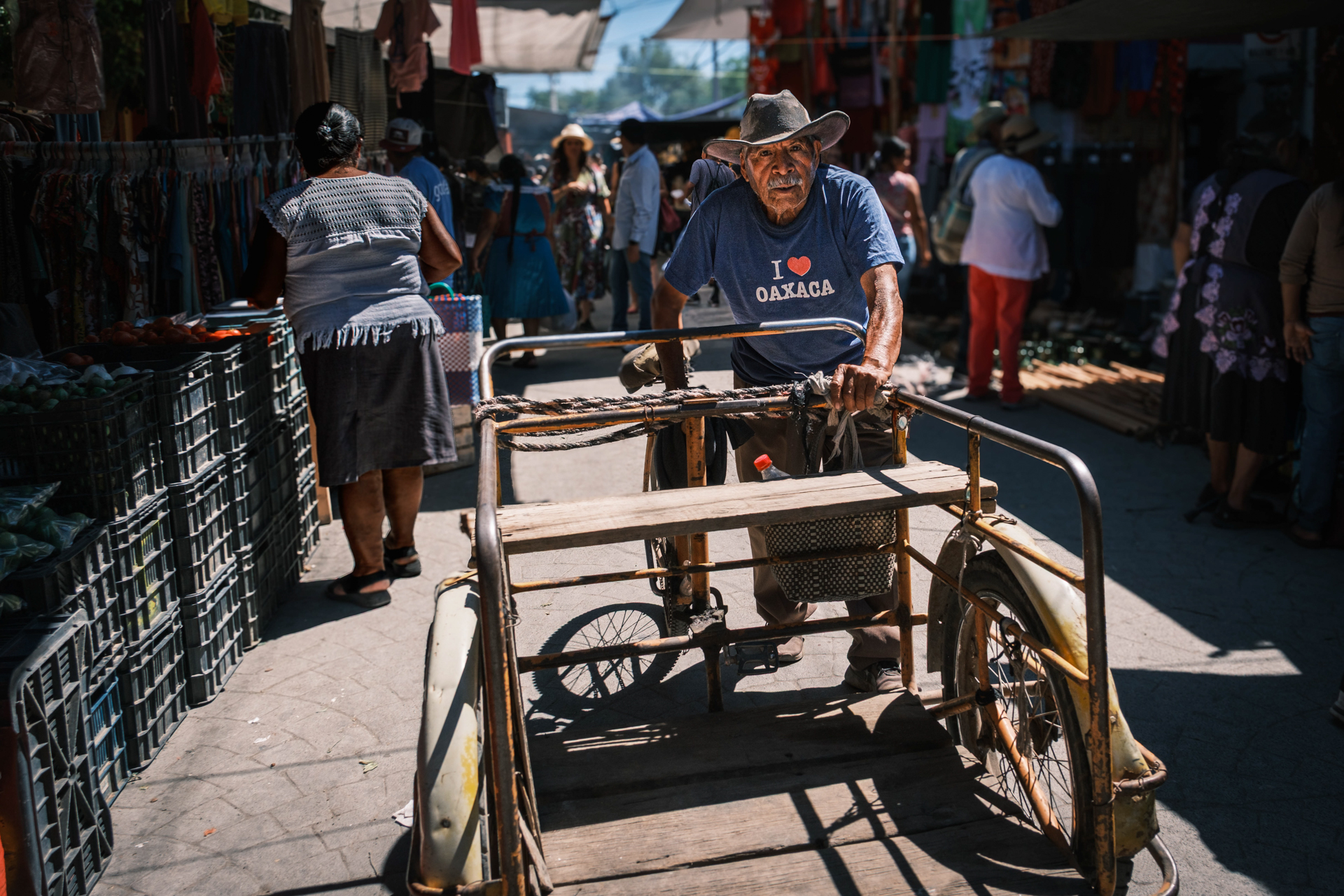 Älterer Mexikaner mit Lastenrad auf einem lokalen Markt.