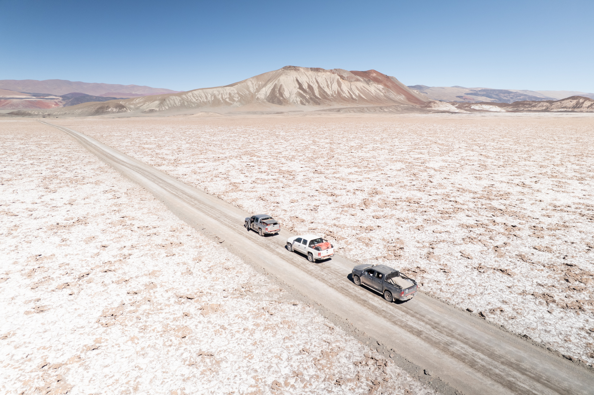 Pick-ups auf einer Piste durch die weite Salzlandschaft der argentinischen Puna.