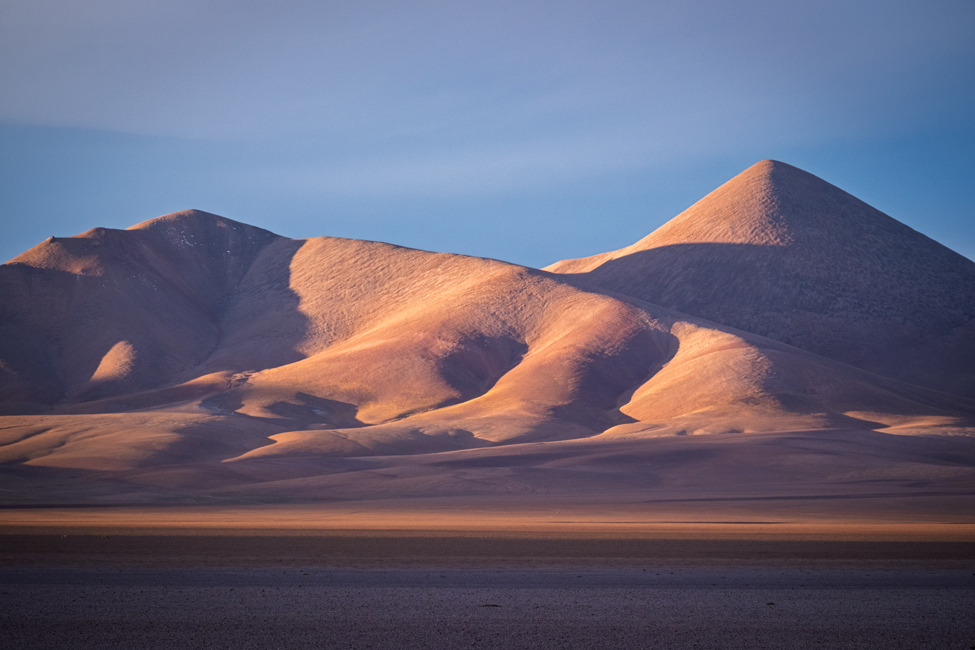 Sanfte Vulkankegel im warmen Abendlicht der argentinischen Puna.