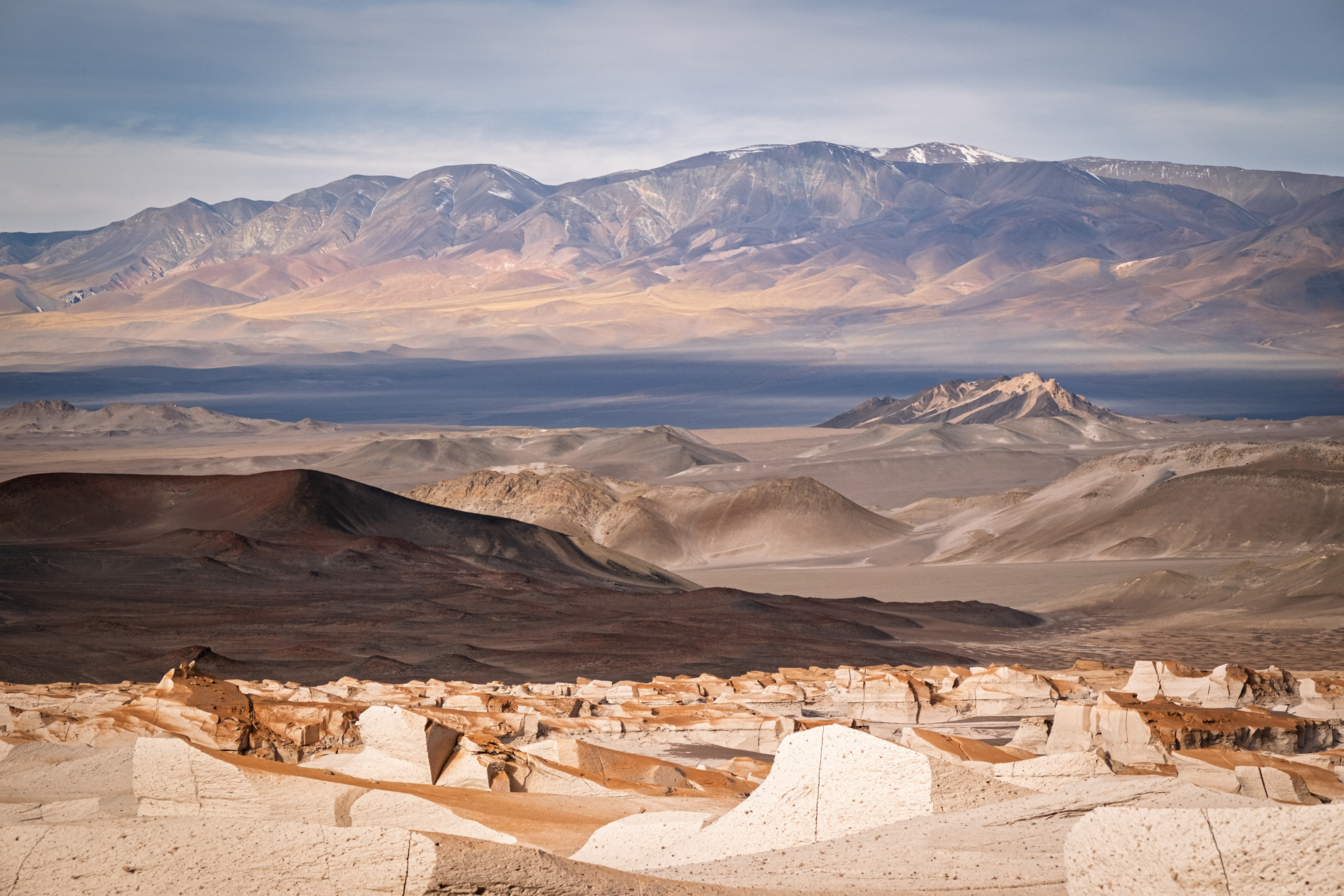 Blick über helle Bimssteinformationen und weite Vulkanlandschaften der argentinischen Puna.
