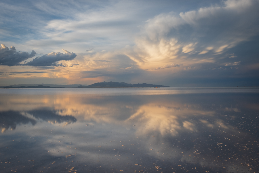 Regenwasser verwandelt den Salzsee in einen riesigen Spiegel unter dramatischem Himmel.