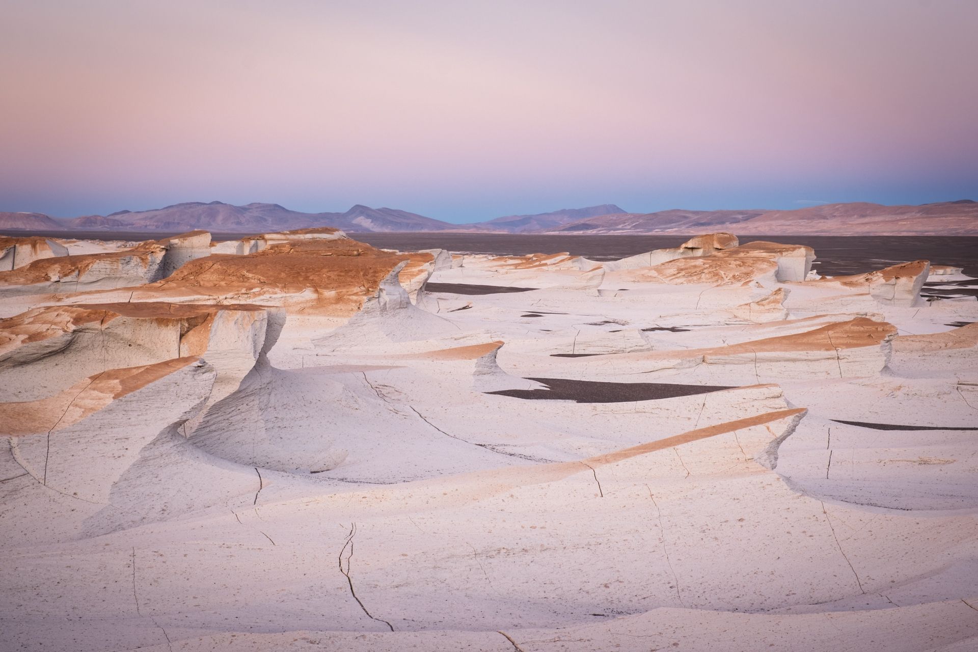 Weiße Bimssteinlandschaft von Campo de Piedra Pómez im zarten Abendlicht.